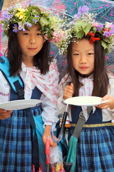 Två japanska flickor i svenska folkdräkter under midsommar i Sweden Hills